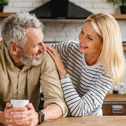 senior-couple-hugging-kitchen-sq