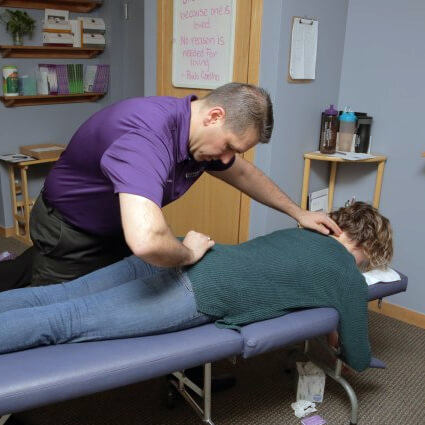 doctor adjusting female practice member stomach lie down