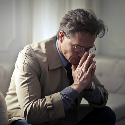 man sitting on couch stressed