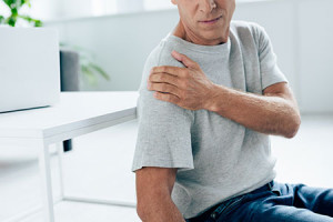 old man with shoulder pain before chiropractor appointment