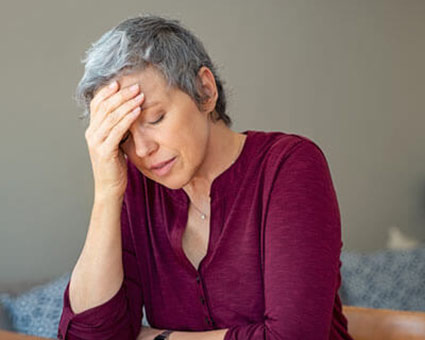 person sitting at table with a headache