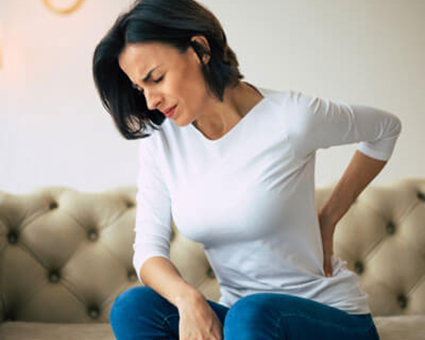 woman on a couch with back pain