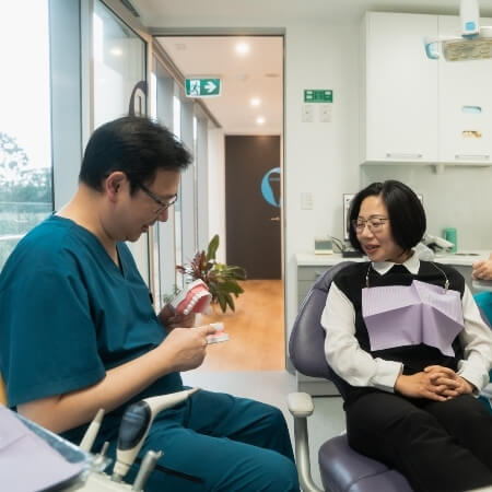 St Leonards dentist Dr Lau explaining oral care to patient