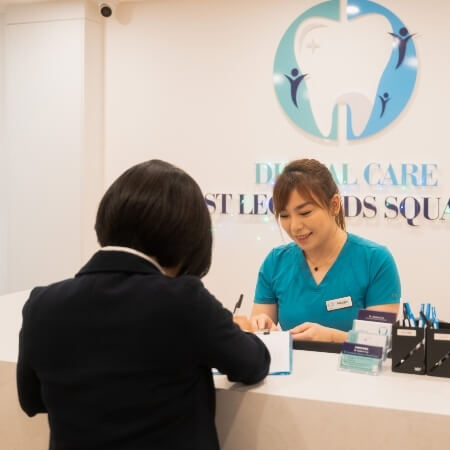 St. Leonards Square Dental Care front desk team talking with patient