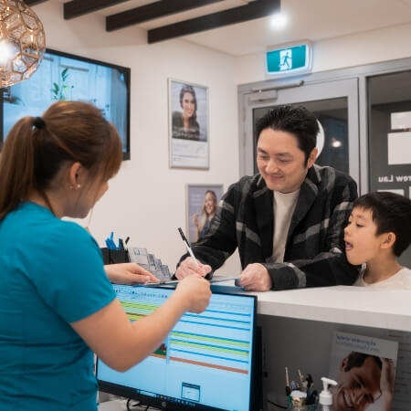 staff talking with patient at front desk