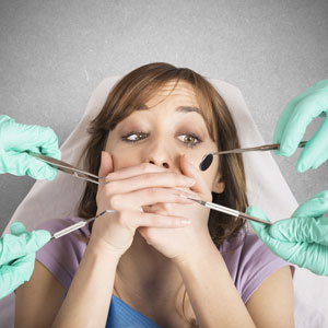woman covering mouth scared at dentist