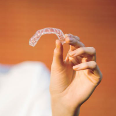person holding a clear aligner