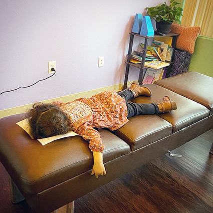 Child laying face down on a chiropractic adjusting table
