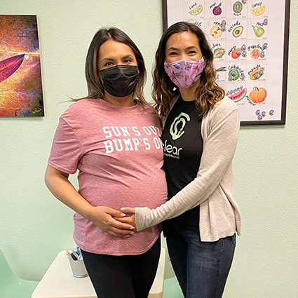 Chiropractor and pregnant patient smiling