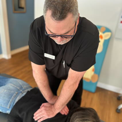 Dr. Chuck doing upper back adjustment