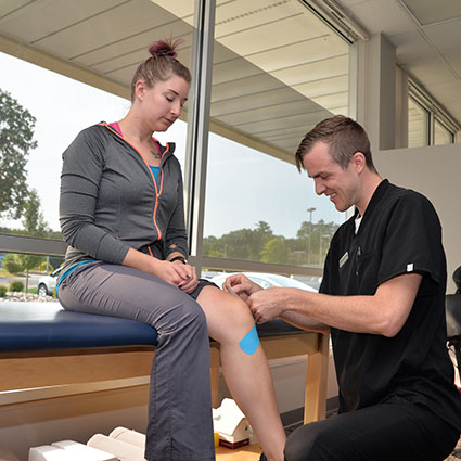 Dr Josh taping patients knee