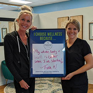 two smiling women holding a sign