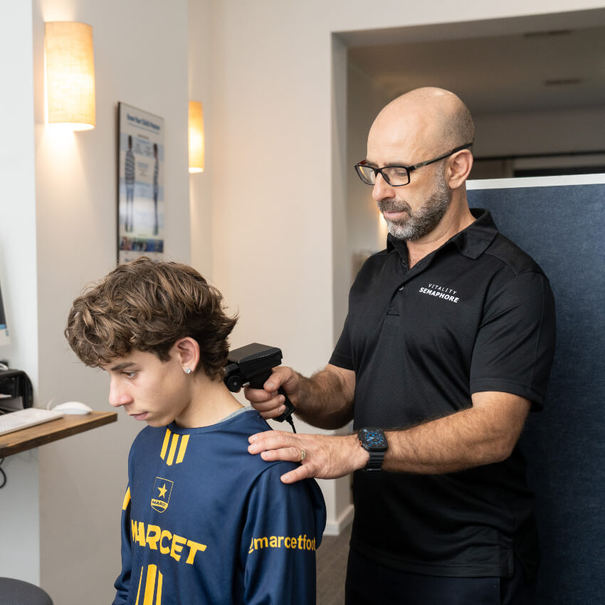 Dr Mario adjusting patients shoulders with tool