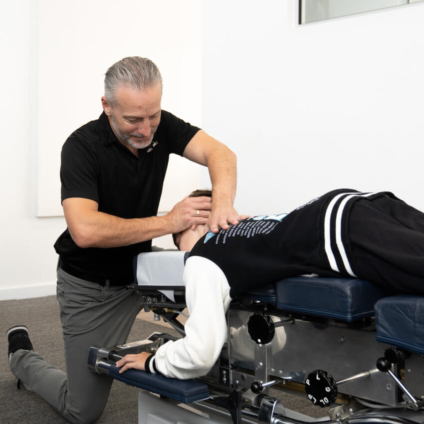 chiropractor adjusting patients neck