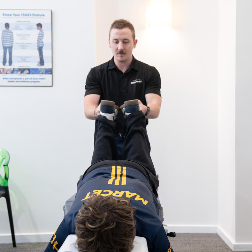 chiropractor adjusting patients legs