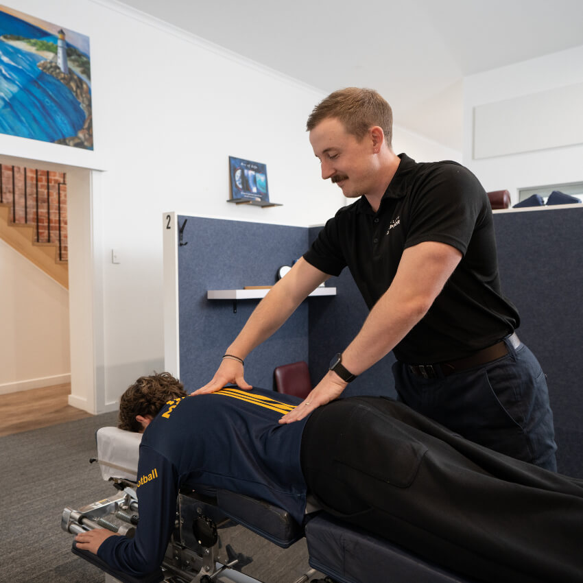 chiropractor adjusting patients back