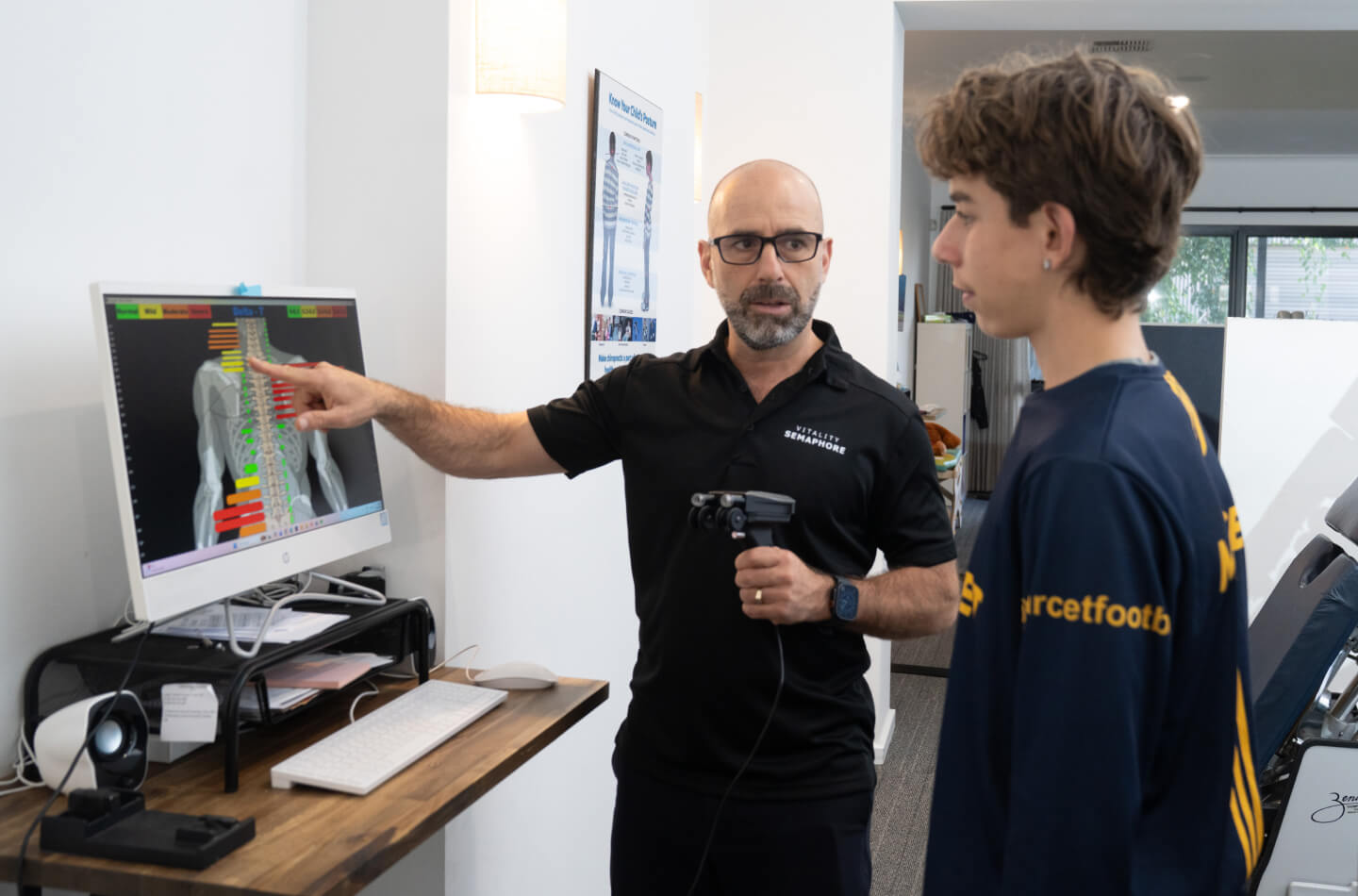 Semaphore chiropractor Dr Mario reviewing chart with patient