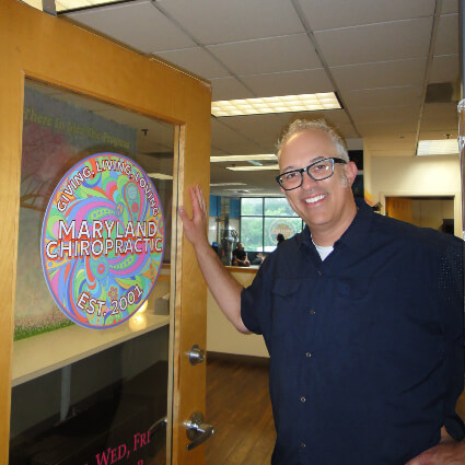 Dr. K standing at Maryland Chiropractic & Rehabilitation office entrance