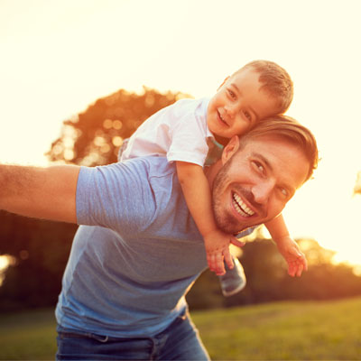 smiling dad with child on back