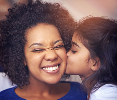 little-girl-kissing-mom-on-the-cheek