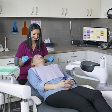patient with hygienist in dental chair