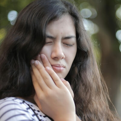 woman holding her jaw with tooth pain