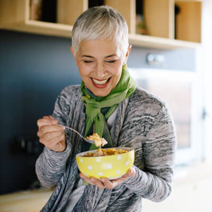 woman smiling and having a bowl of cereal 