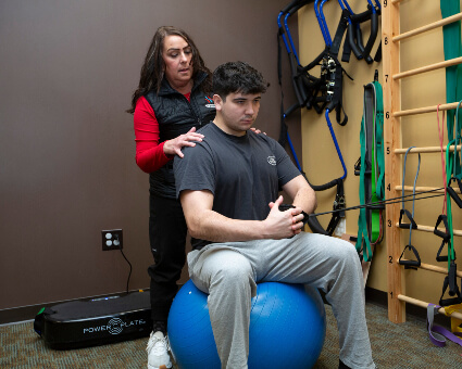 Patient sitting on exercise ball