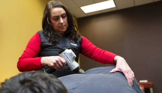 Midwest Sport and Spine team member using tool on patient's back