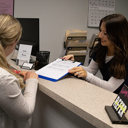 Patient at our front desk getting their paperwork