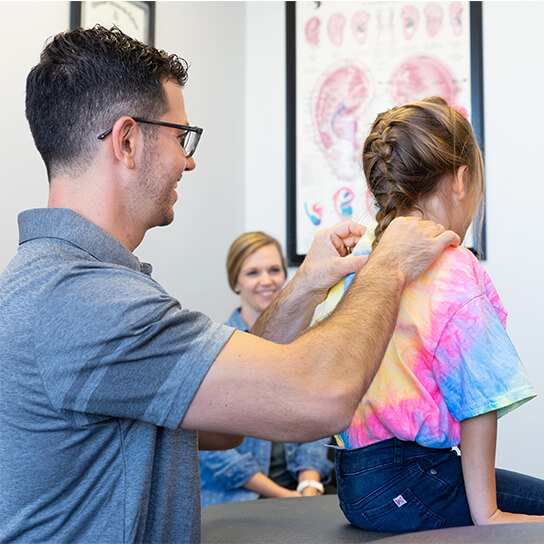 Dr. Harlan adjusting girls neck