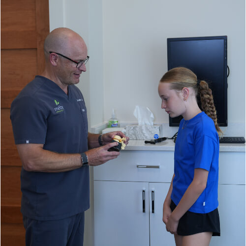 Chiropractor in discussion with young patient