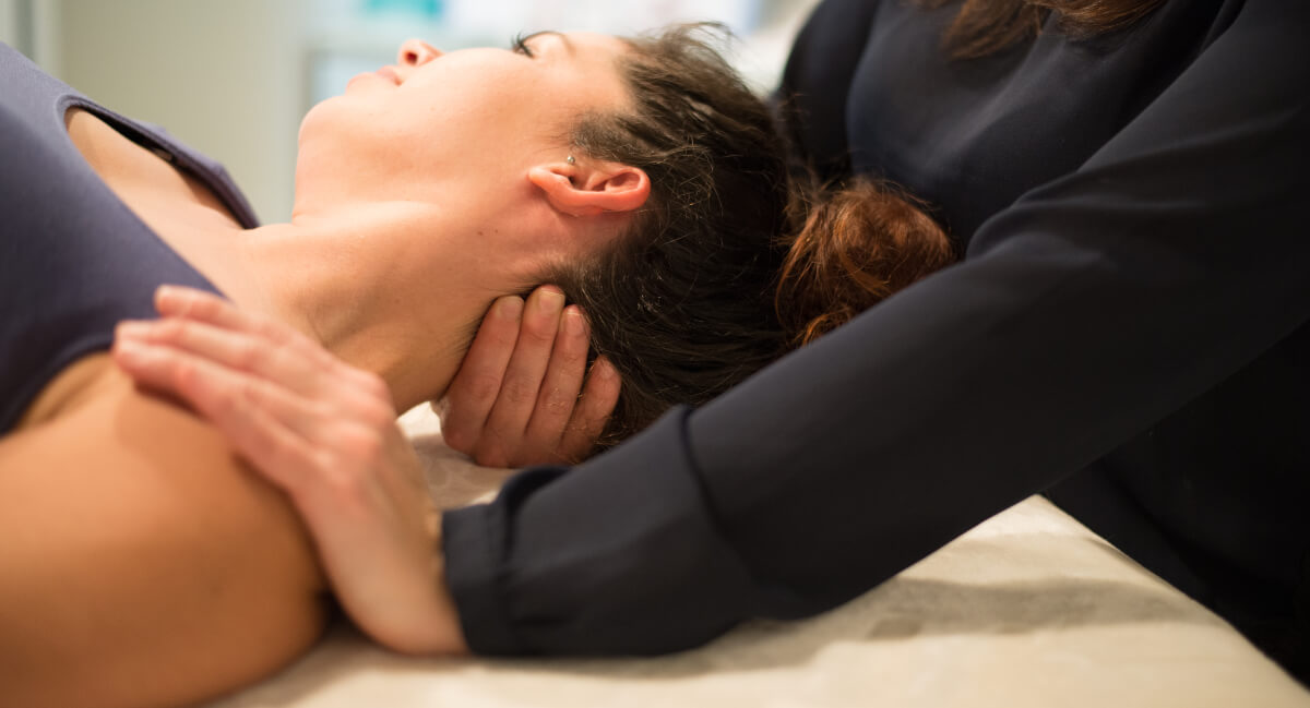 Chiropractic adjustment applied to female patient's neck