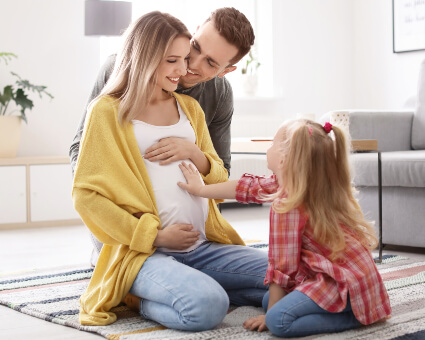 Pregnant mom with husband and young daughter