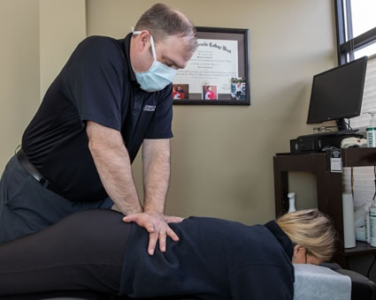 Doctor adjusting woman's back