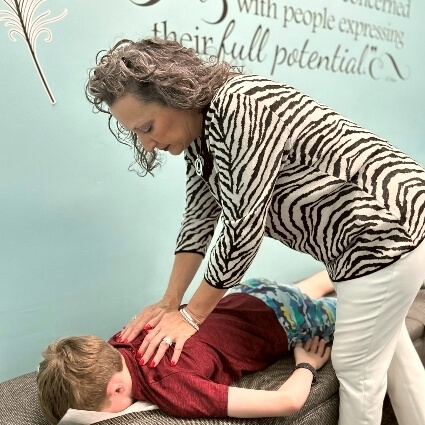 Dr Carol adjusting childs back