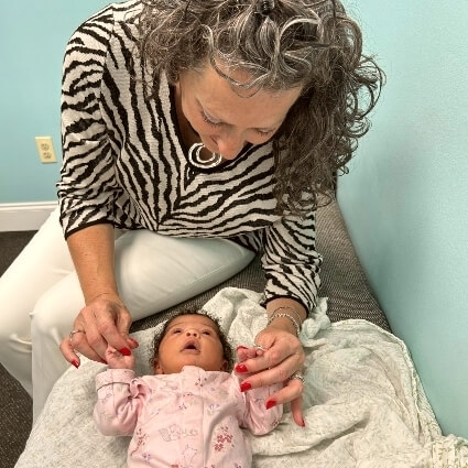 Dr Carol adjusting baby