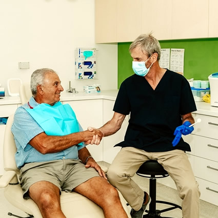 Dentist shaking mans hand