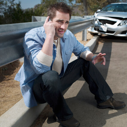 Man on phone after car crash