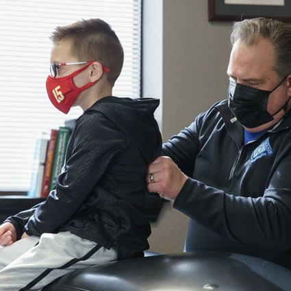 doctor adjusting boy in mask