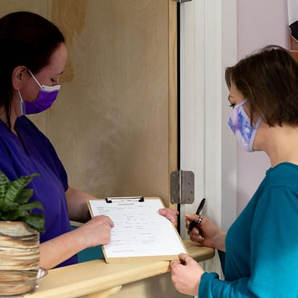 Patient at reception desk with paperwork