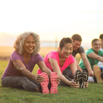 group of people stretching in a park