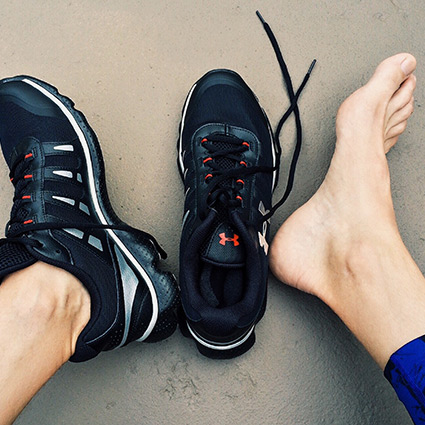 man with running shoes on on the beach