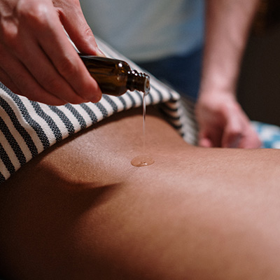 person putting massage oil on skin