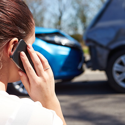 Woman talking on her cellphone after a car accident