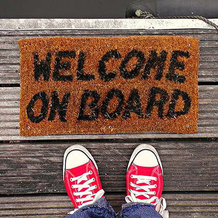 person standing next to a door mat that says 