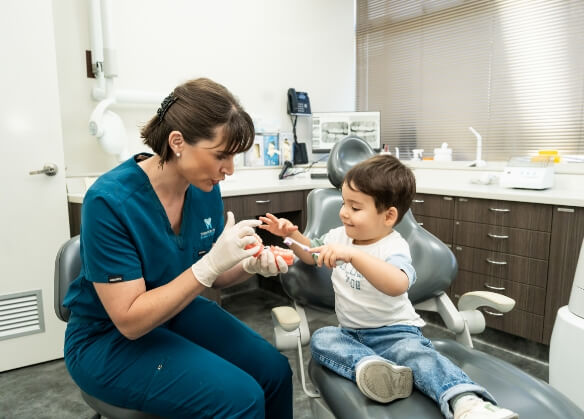 Dentist with kid holding toothbrush
