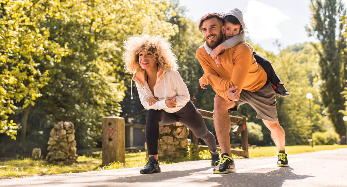 Hombre con un niño a su espalda preparándose para correr.