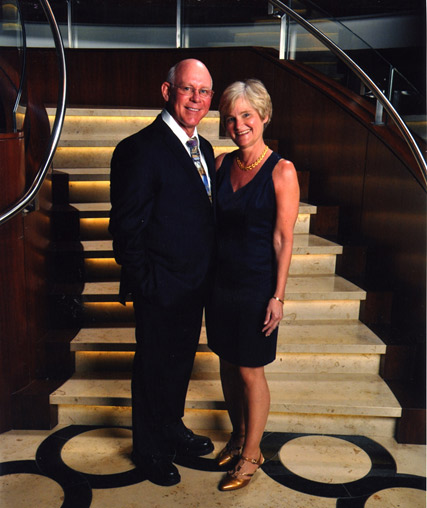Doctor Pickens and Nancy standing at the base of the stairway in formal attire.