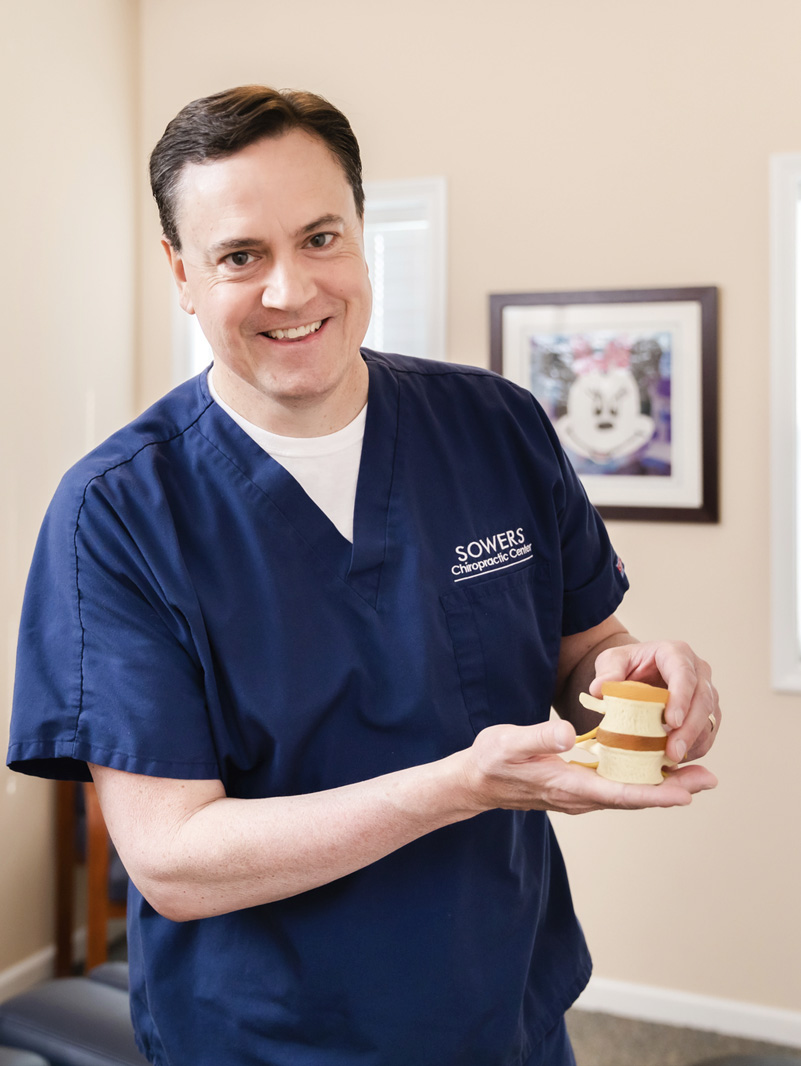 Dr. Dan smiling with model of spine